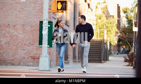 Young Hispanic couple walking hand in hand in Brooklyn Stock Photo