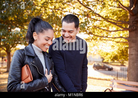 Young Hispanic couple walking hand in hand in Brooklyn park Stock Photo