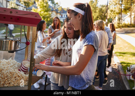 Girls serve themselves popcorn at neighbourhood block party Stock Photo