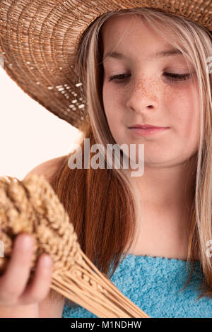 Little girl holding wheat ears in her  hands Stock Photo