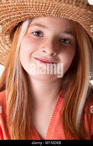 portrait of beautiful freckled young girl wearing straw hat Stock Photo