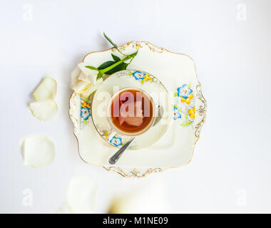 flatlay with elegant tea set with rose flower reflection iat the urface of liquid surrounde by rose petals and flowers Stock Photo