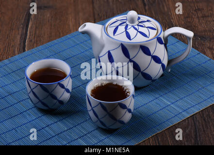 Hot tea is in two cups. Cups on a blue mat Stock Photo