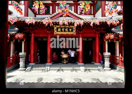 The entrance to the Buddha Tooth Relic Temple in historic Chinatown Singapore decorated with red lanterns and flower celebrating Chinese New Year Stock Photo