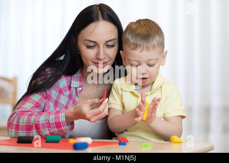 Woman teaches child son handcraft at home Stock Photo