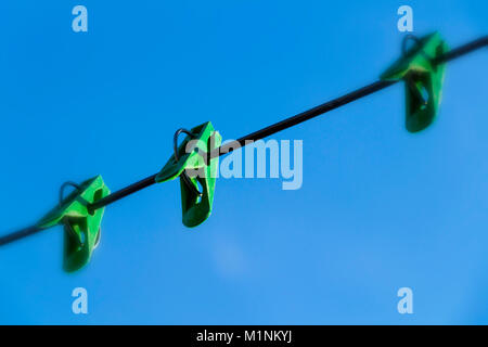 Linen clothespins on a rope close-up against a blue sky. Stock Photo
