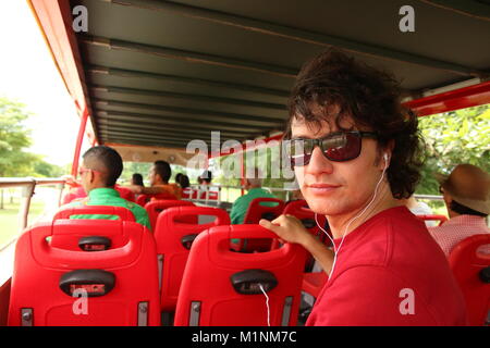 Young man sitting on a double decker red bus in Panama City douring a bus tour. Stock Photo