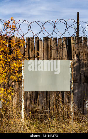 A metal sign near the fence of the forbidden danger zone. Stock Photo