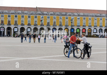 A young couple with their small child sitting on the back of the father's bicycle in the Praça do Comércio, Lisbon, Portugal Stock Photo