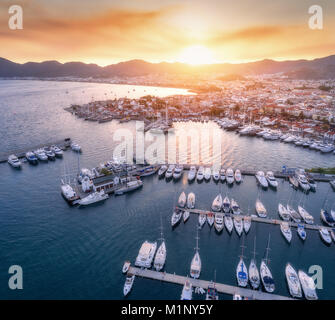 Aerial view of boats and yachts against beautiful architecture at sunset in Marmaris. Landscape with boats in marina bay, piers, sea, city, mountains, Stock Photo