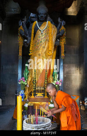 Novice monk and Vishnu statue, Angkor Wat, UNESCO World Heritage Site, Siem Reap, Cambodia, Indochina, Southeast Asia, Asia Stock Photo