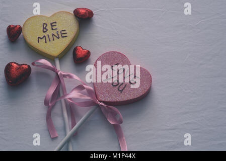 Be mine and Love you hearts with smaller hearts on top of a white bed sheet with text space on the top right. Stock Photo