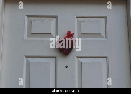 Heart made of multiple small roses hanging on a front door Stock Photo