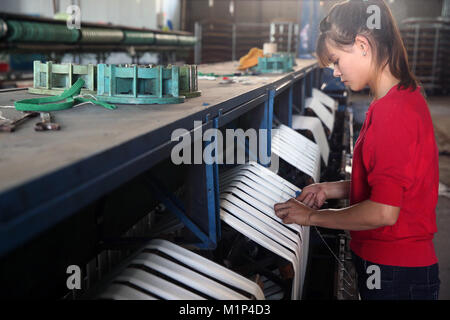 Woman working on silk spinning machine in traditional silk factory, Dalat, Vietnam, Indochina, Southeast Asia, Asia Stock Photo