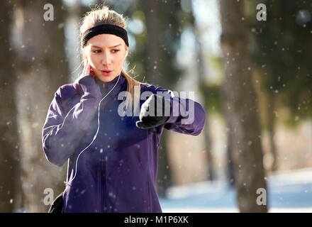 Female measures pulse on training outdoor Stock Photo