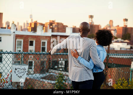 Young black couple embracing on Brooklyn rooftop, back view Stock Photo