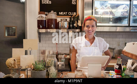 Young woman waiting behind the counter in a butcher's shop Stock Photo
