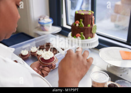 Black woman preparing food in a bakery, over shoulder view Stock Photo
