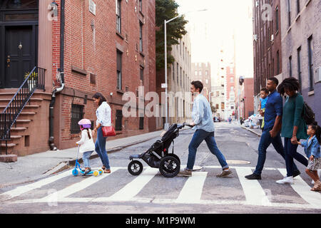 Two families with daughters crossing road Stock Photo