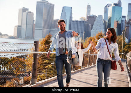 Young family with daughter taking a walk on footbridge Stock Photo