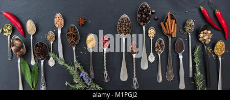 Spices and herbs on black stone background, top view, banner Stock Photo