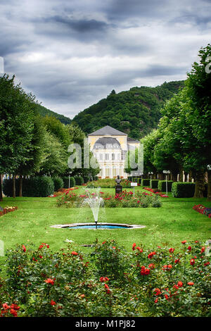 Outdoor colorful scenic image of the famous casino in historical spa town Bad Ems, Germany,a park,roses,trees,statue and fountain in front,green hills Stock Photo