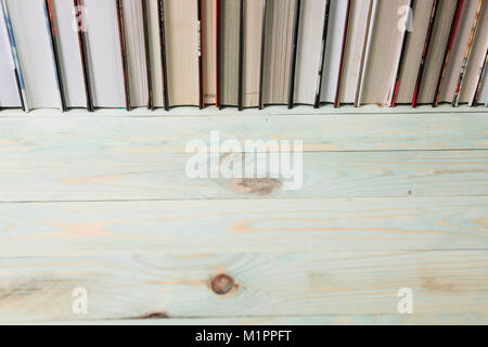 Pile of various books on bright wooden background. With copy space for your text Stock Photo