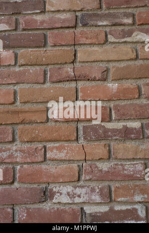 vertical red brick exterior wall with crack Stock Photo