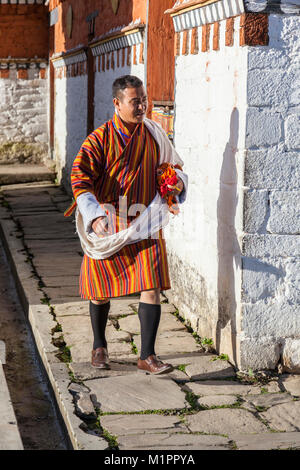 Bumthang, Bhutan.  Bhutanese Man Wearing Traditional Gho.  Jambay Lhakhang Monastery. Stock Photo