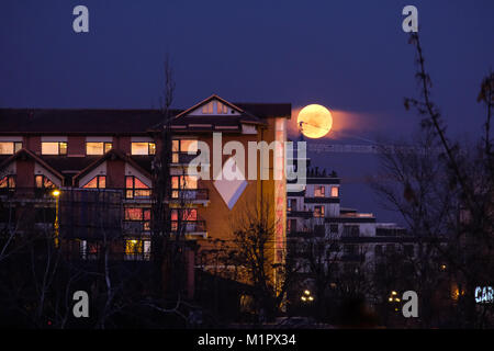 Bucharest, ROMANIA - January 31 2018: Super Blue Blood Moon rising close to Hotel Caro in Bucharest. Rare lunar trifecta. BUCHAREST January 31 2018 Stock Photo