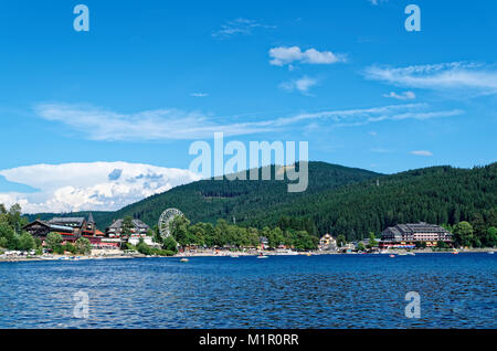 Traditional houses and Ferris Wheel on the promenade of the Titi lake (Titisee), Black Forest, Germany Stock Photo