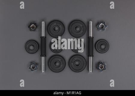 flat lay with various metal barbells and weight plates isolated on grey Stock Photo