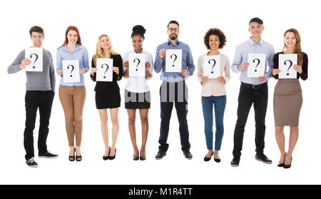 Group Of Happy College Students With Question Mark Sign Standing On White Background Stock Photo
