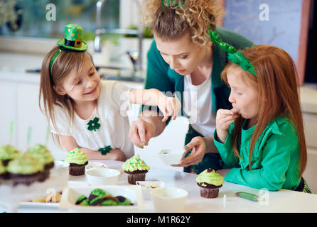 Woman with children decorating cupcakes Stock Photo