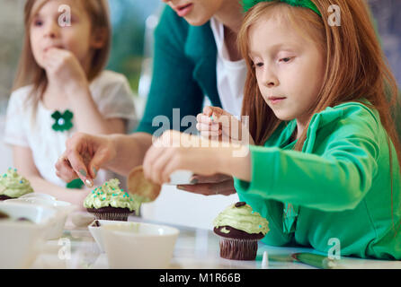 Family decorating cupcakes at kitchen Stock Photo