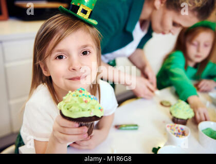 Portrait of cheerful girl showing cupcake Stock Photo