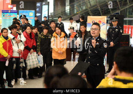 Nanning, China's Guangxi Province. 1st Feb, 2018. A police officer warns passengers of deceitful card tricks at Nanning East Railway Station, in Nanning, south China's Guangxi Province, Feb. 1, 2018. The 2018 Spring Festival travel rush, known as the Chunyun, started on Thursday and will last till March 12. About 2.98 billion trips are expected to be made during the Chunyun. The Spring Festival, or Chinese Lunar New Year, falls on Feb. 16 this year. Credit: Lu Boan/Xinhua/Alamy Live News Stock Photo