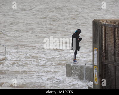 Sheerness, Kent, UK. 1st Feb, 2018. UK Weather: a young woman takes a surge tide selfie as the Neptune Jetty is covered by water during today's surge tide. Sunny spells but with a strong and cold westerly wind. Credit: James Bell/Alamy Live News Stock Photo