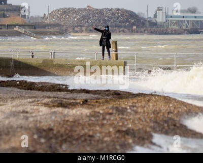 Sheerness, Kent, UK. 1st Feb, 2018. UK Weather: a young woman takes a surge tide selfie as the Neptune Jetty is covered by water during today's surge tide. Sunny spells but with a strong and cold westerly wind. Credit: James Bell/Alamy Live News Stock Photo