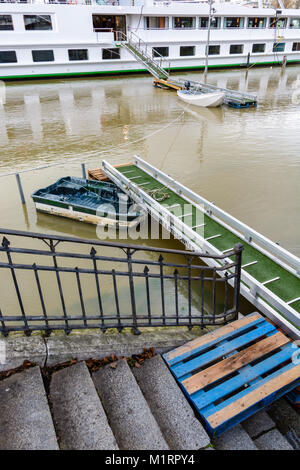 During a flooding episode, the only way to reach the riverboats mooring on the wharf of the Seine in Paris is to use a small rowing boat from one gang Stock Photo