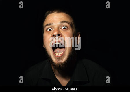 Scared face of spooky man in the dark. The man is yelling Stock Photo ...