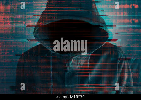 Cybersecurity, computer hacker with hoodie and obscured face, computer code overlaying image Stock Photo