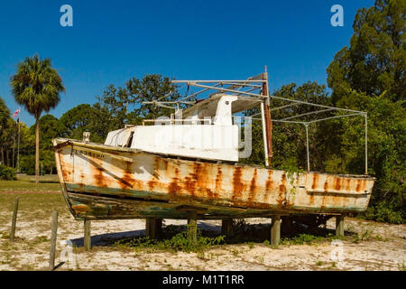 Small fishing boat skiff with outboard motor and seats anchored