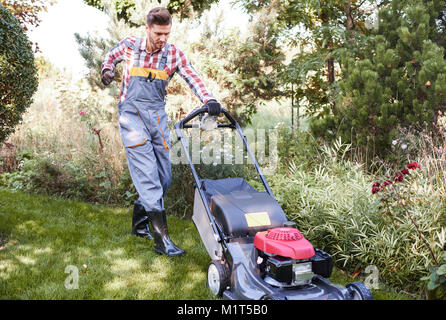 Gardener turning on a mower Stock Photo