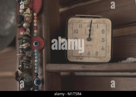 Old antique clock and beads on wooden shelf Stock Photo