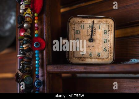 Old antique clock and beads on wooden shelf Stock Photo