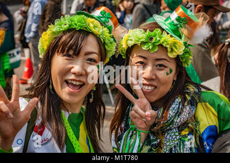 Close up of two Japanese ladies wearing green and posing. St. Patrick's Day Tokyo Parade 2017. Stock Photo