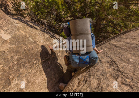 Backpacking route through a crack in a fin within Salt Creek Canyon in The Needles District of Canyonlands National Park, Utah, USA Stock Photo