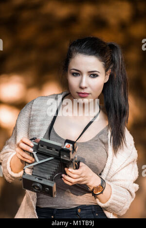 Beautiful Young Woman Holding Vintage Old Camera, classic retro style photograph Stock Photo