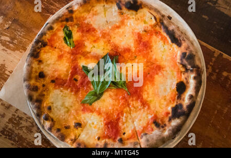 A pizza Margarita with mozzarella cheese, tomatoes, and basil Stock Photo